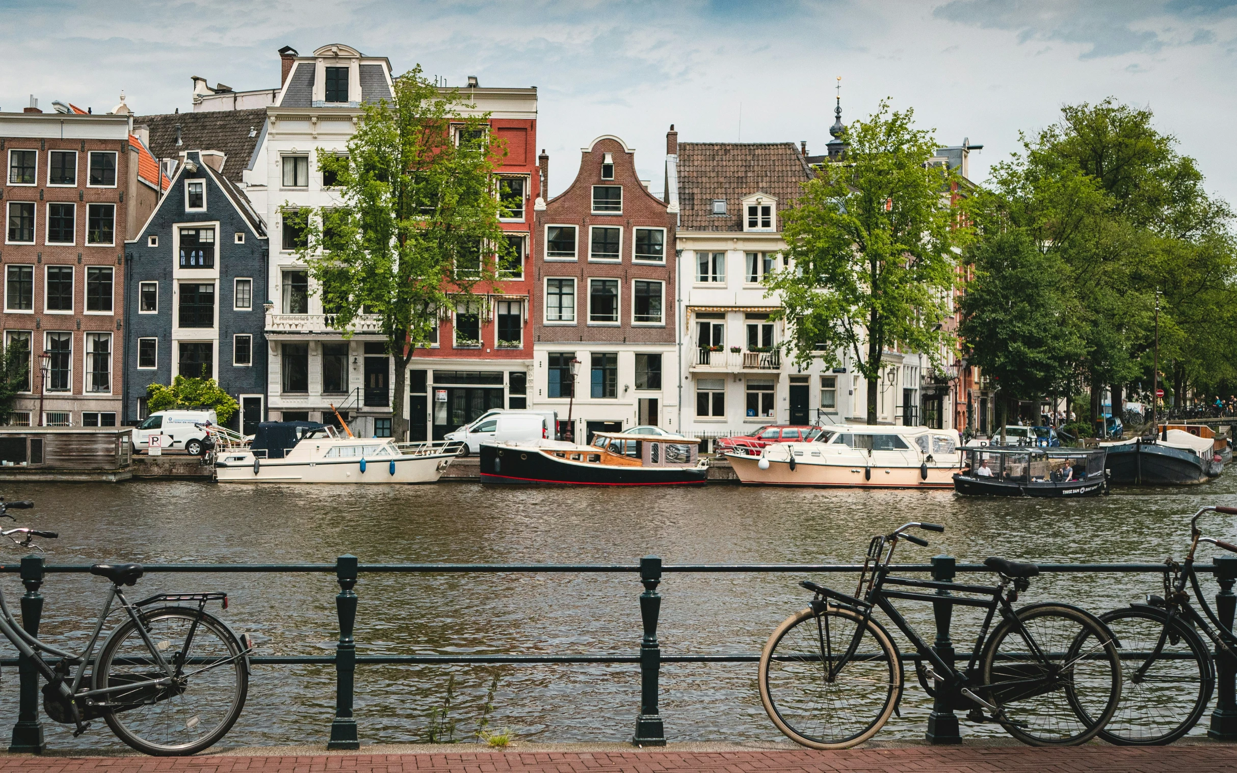 two bikes are parked along side the water