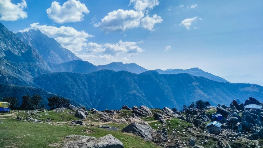 the view from the top of a mountain shows rocks and grassy field