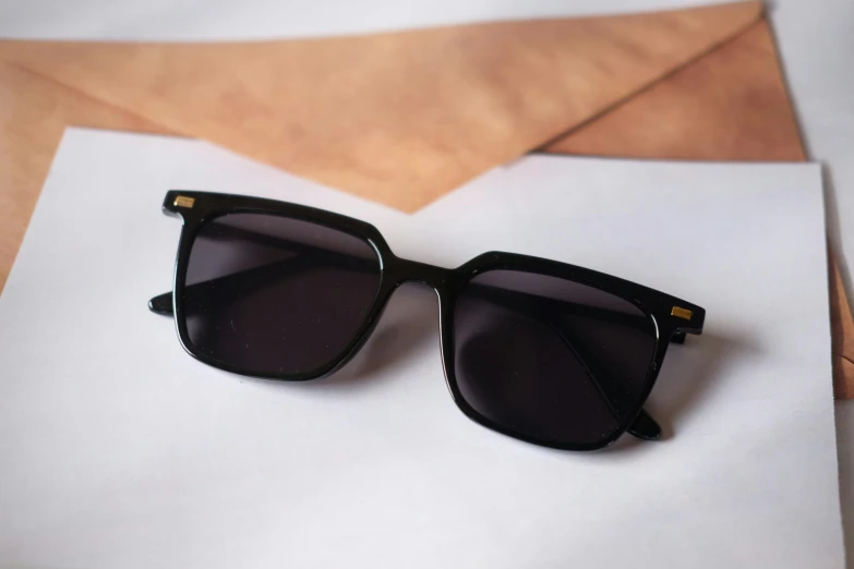 a black pair of sunglasses on a piece of paper
