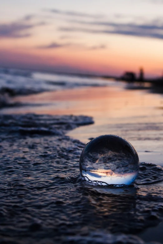 a glass ball on the shore at dusk