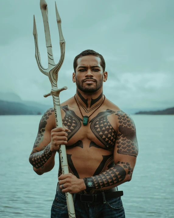 a man with tattoos holding an oar in his right hand