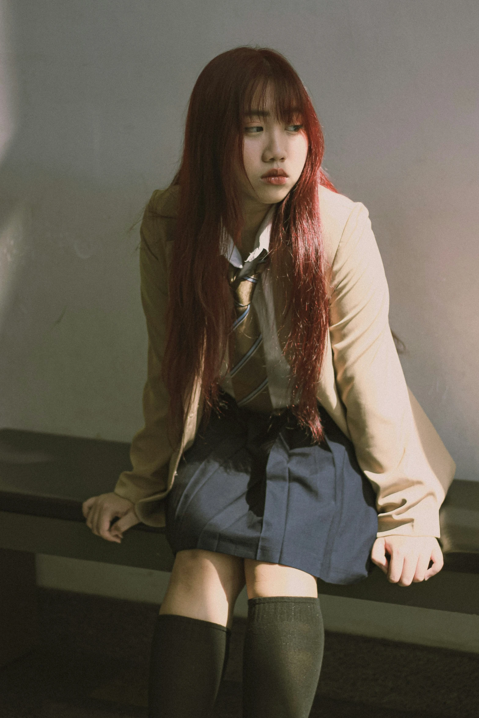 a young woman with long hair sitting on a bench