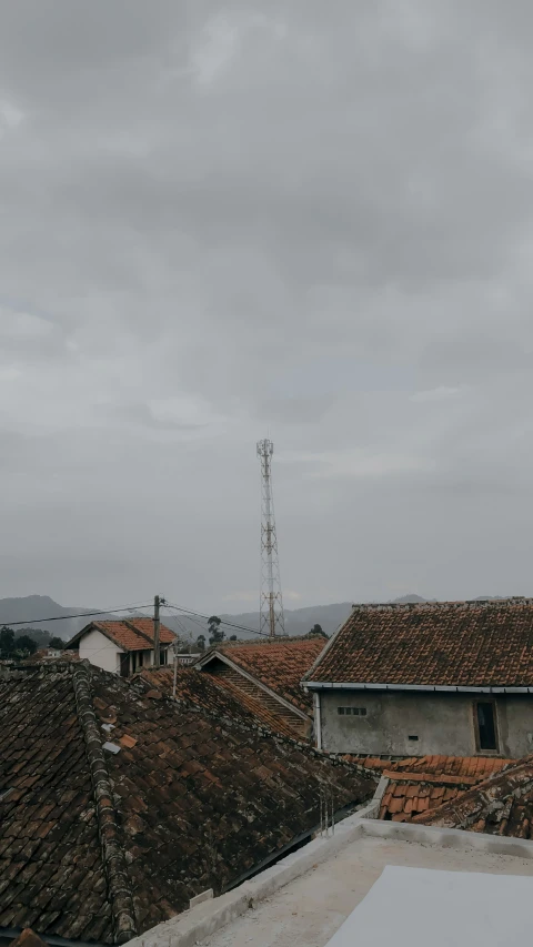 a tall tower stands over an old rooftop