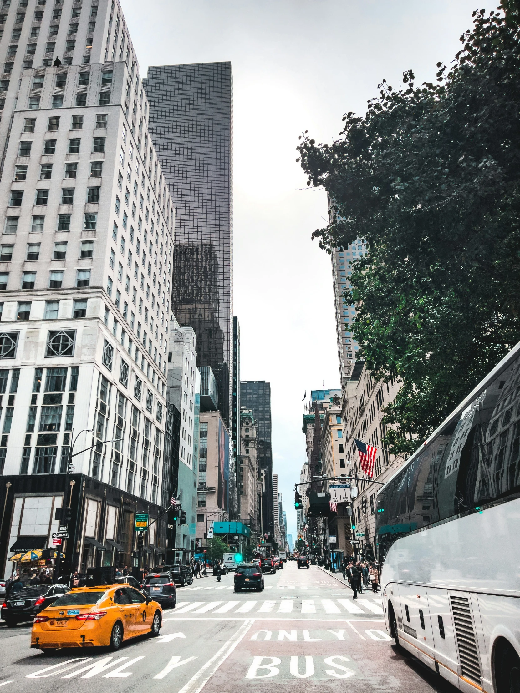 a yellow taxi cab driving down a street next to tall buildings