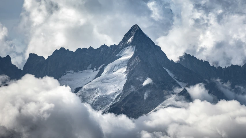 some very tall mountains that are covered in clouds