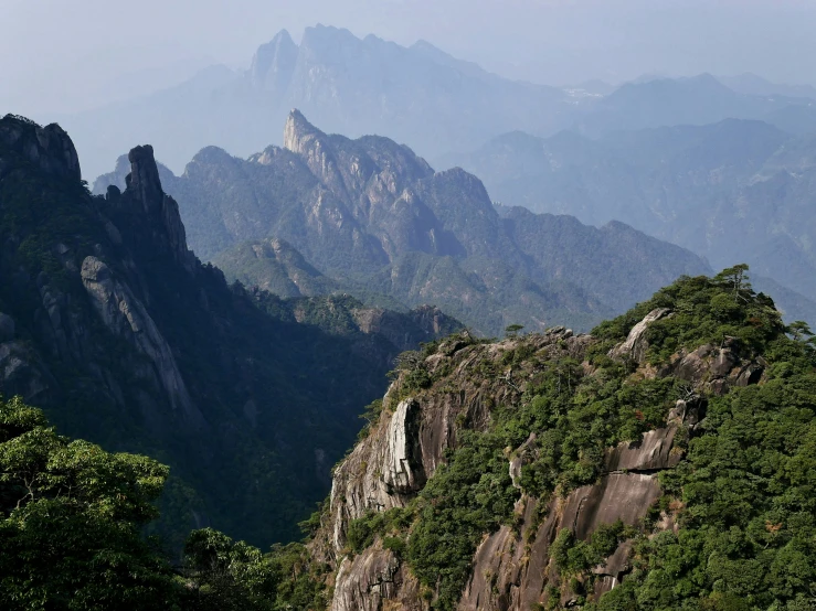 a view of mountains covered with green trees