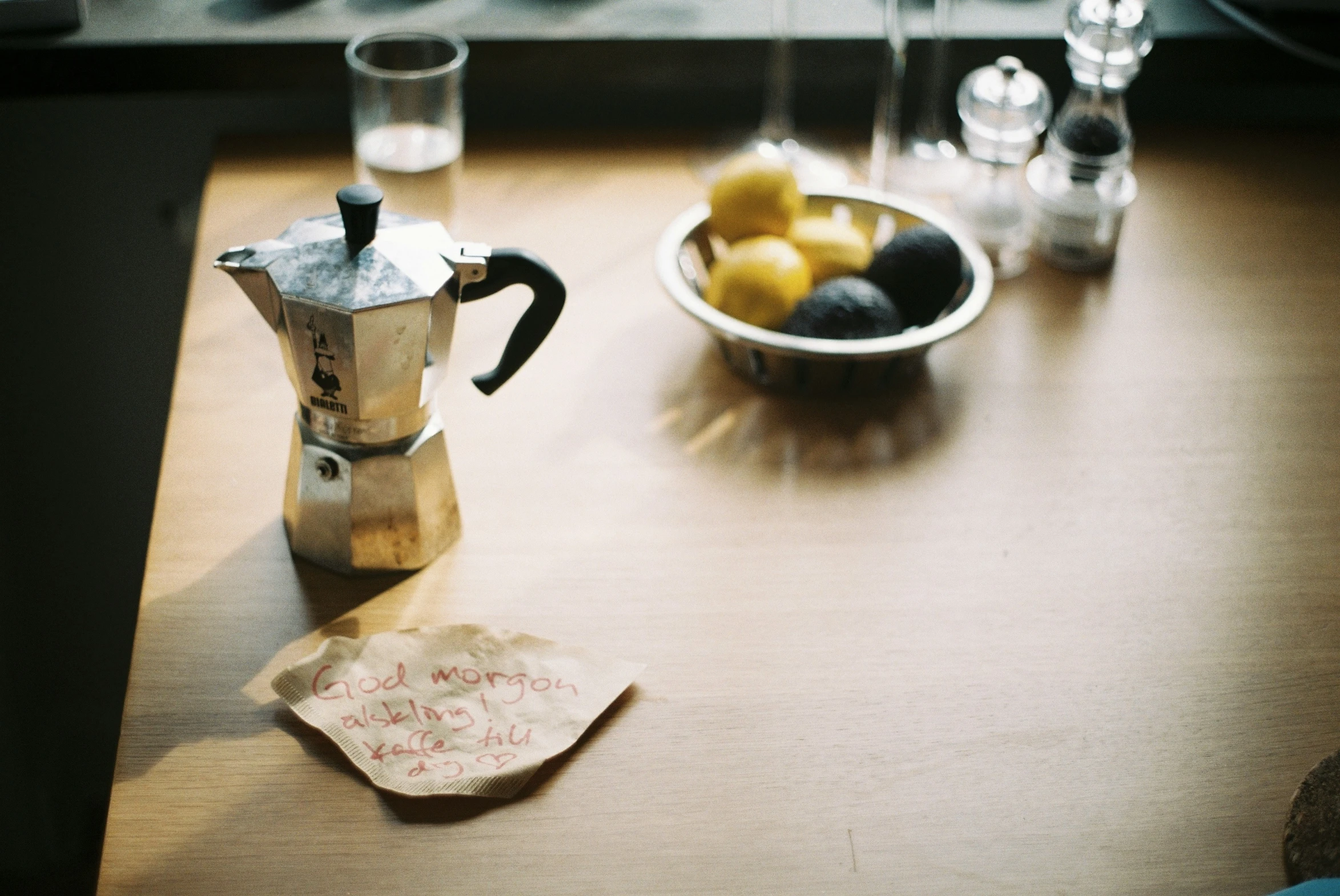 a cup on the table with lemons and a jug