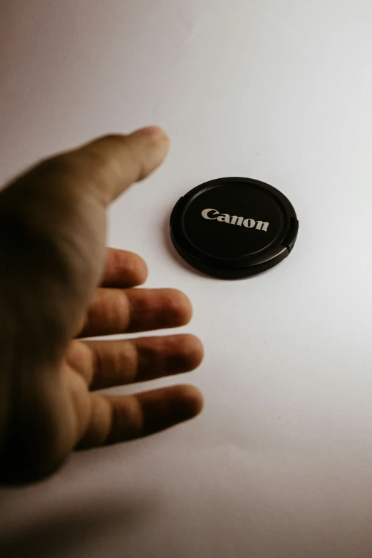 small camera lens cap lying on top of a white surface