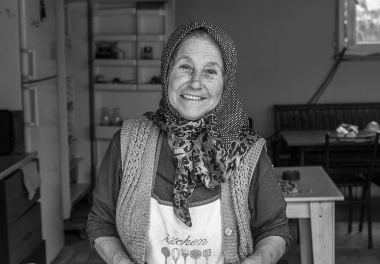 a woman in a scarf and shirt smiles for the camera