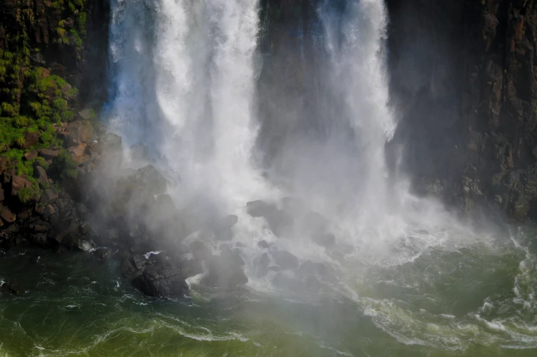 an overhead view of a waterfall with water gushing out from the base