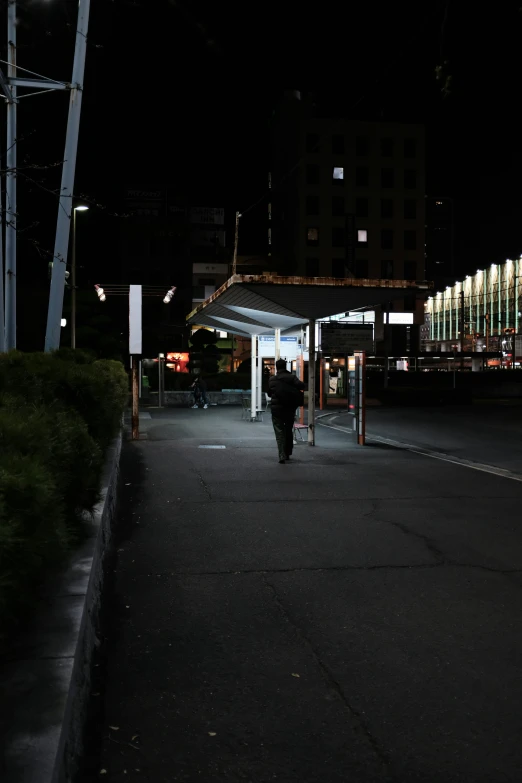 people are walking in the dark near a walkway