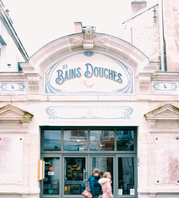 two young children walking in front of a doughnut shop