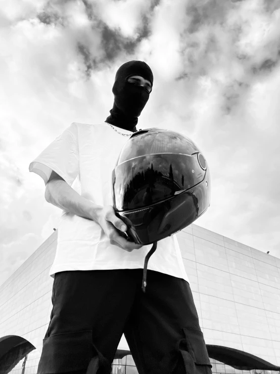 a person standing in front of a tall building with a helmet on