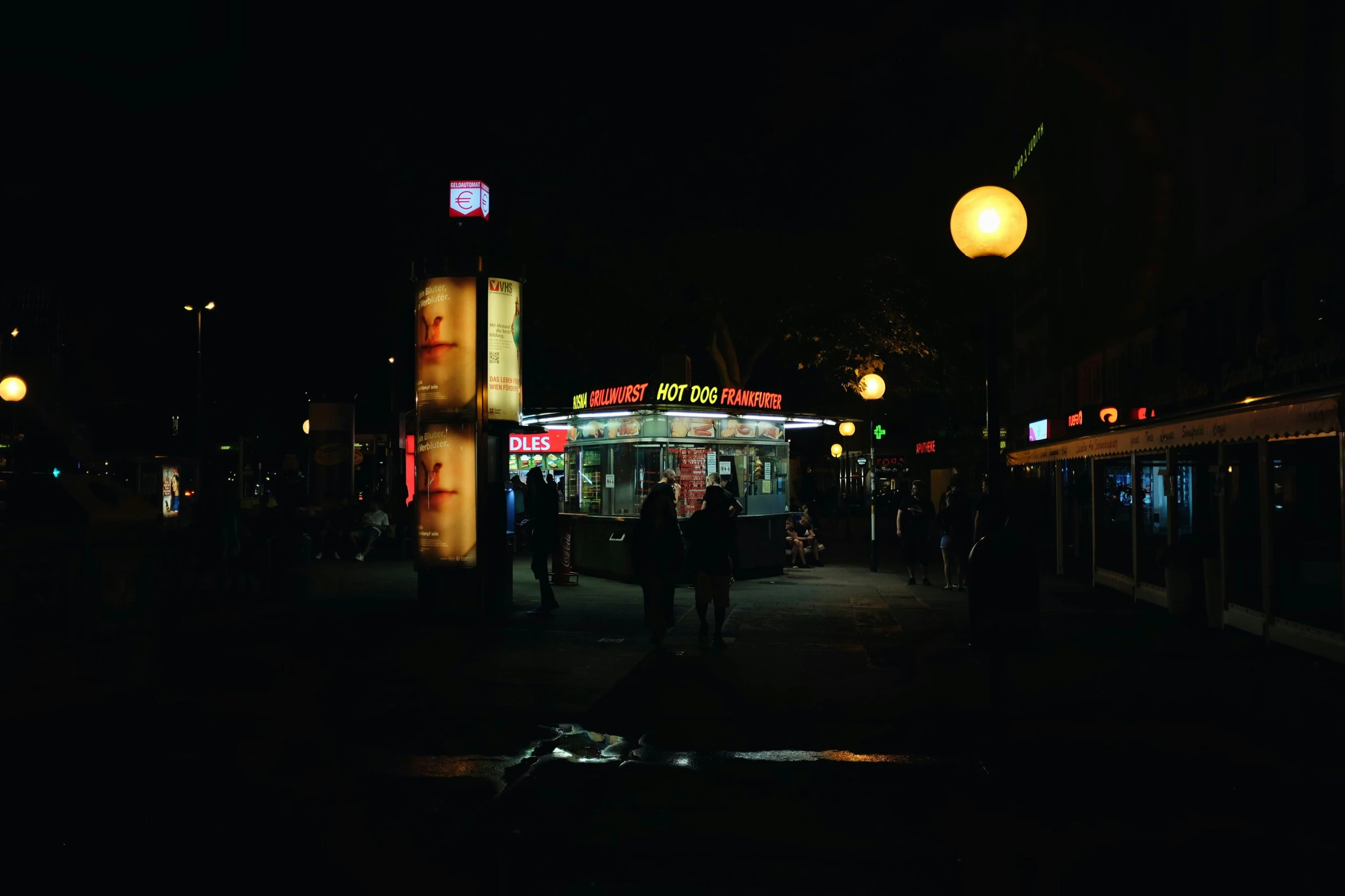 a darkened image of a night time shopping street