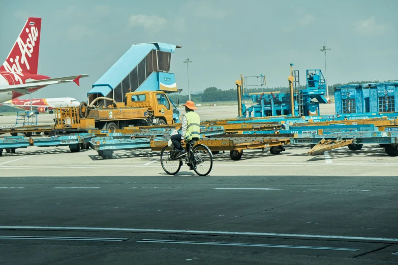 a man is riding a bicycle near a bunch of different types of jet planes