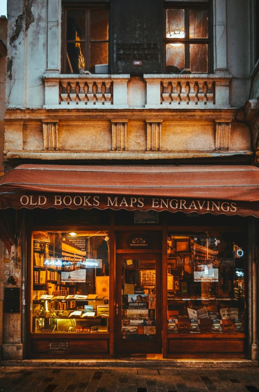 an old book store front with lit signs on it