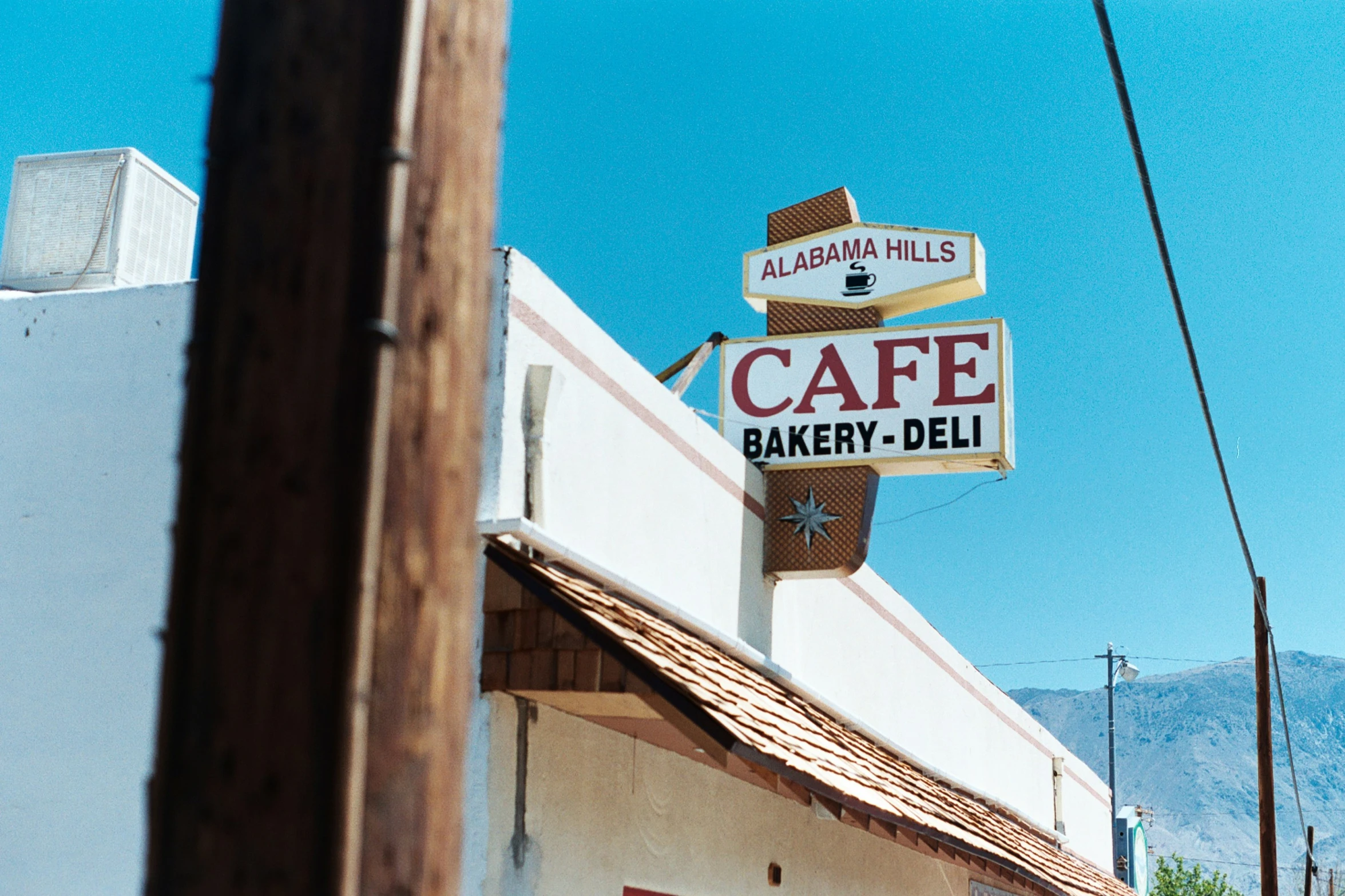 a sign hanging from the side of a building advertising a bakery