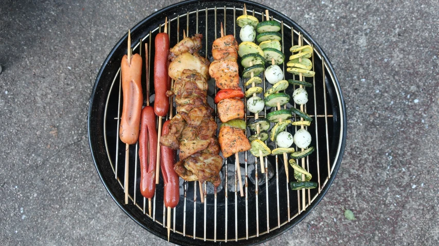 several different food cooking on the bbq outdoors