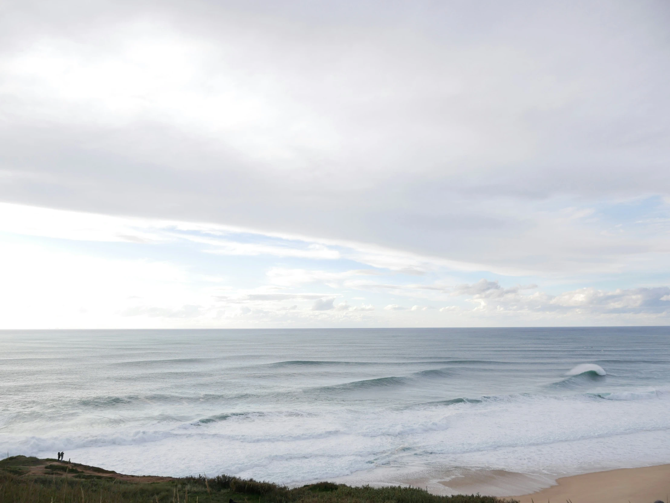 a beach near the ocean with waves coming in