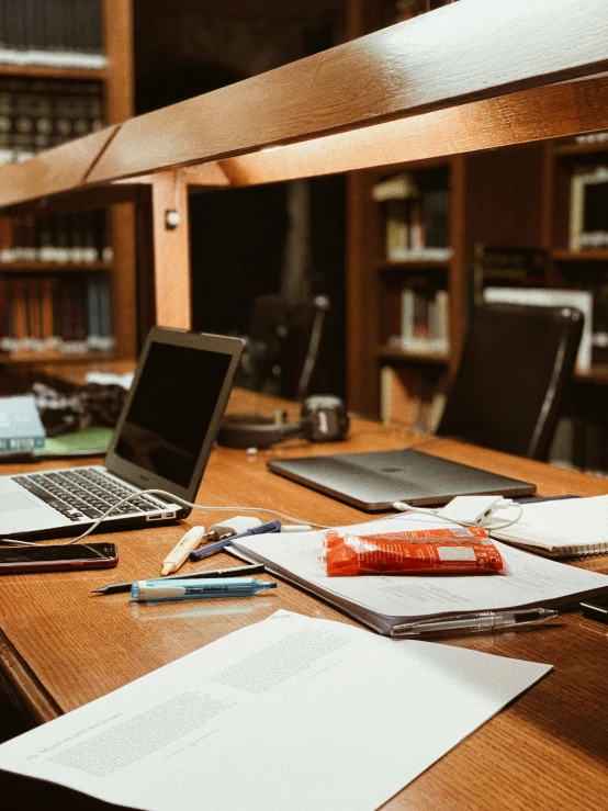 a laptop computer and various papers on a desk