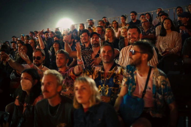 a crowd of people are standing in a stadium