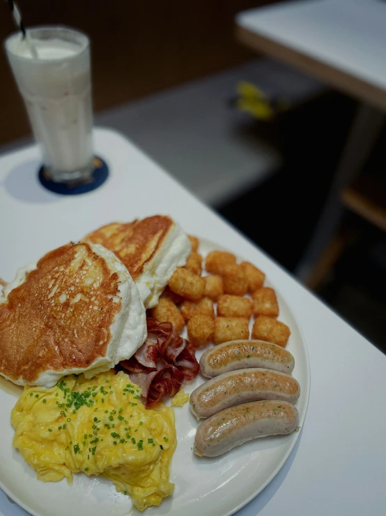 a breakfast plate of bacon, eggs, and pancakes