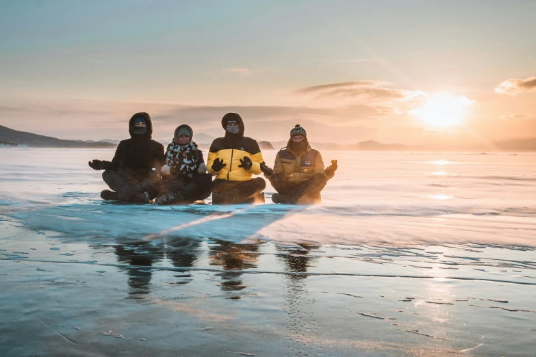 five people sitting on a large white surfboard in the water