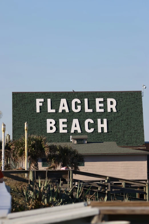 a sign showing the name of a beach on a large brick building