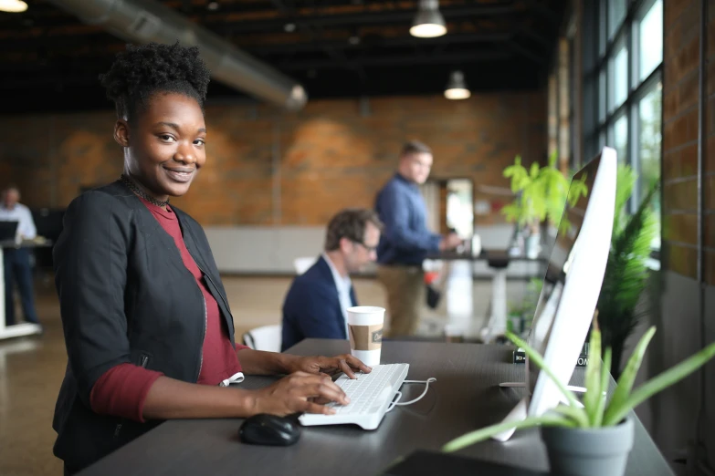 there is a smiling woman on a computer