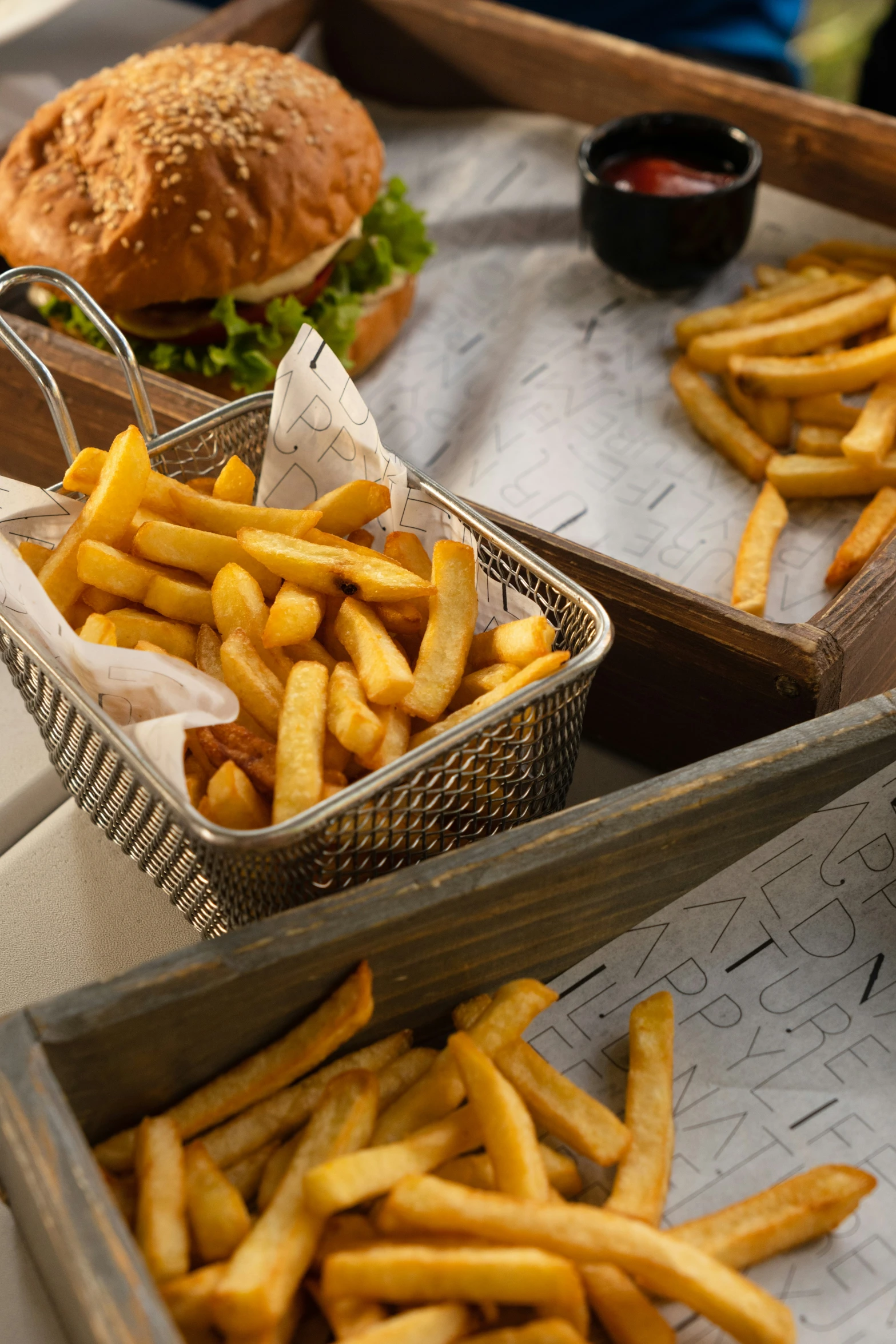 several different trays of food including hamburger, french fries and ketchup