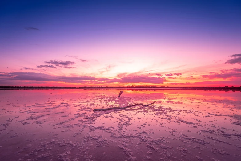 the water is clear and shiny during a colorful sunset