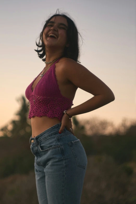 woman in pink tank top standing and laughing