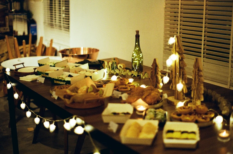 a dinner table set for two with wine bottles, candles, and food