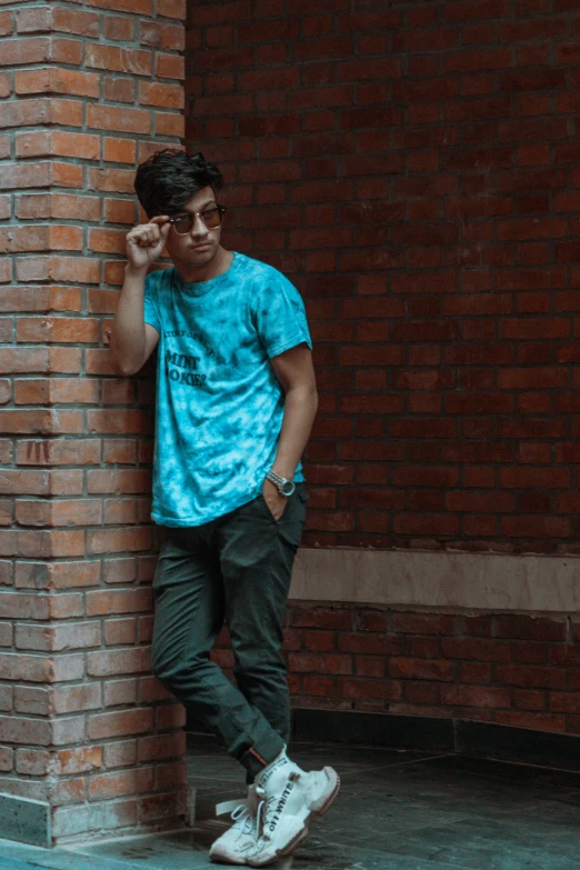 a man standing in front of a brick wall next to a tall wall