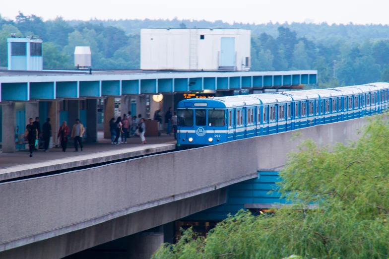 the commuter train is traveling over the bridge