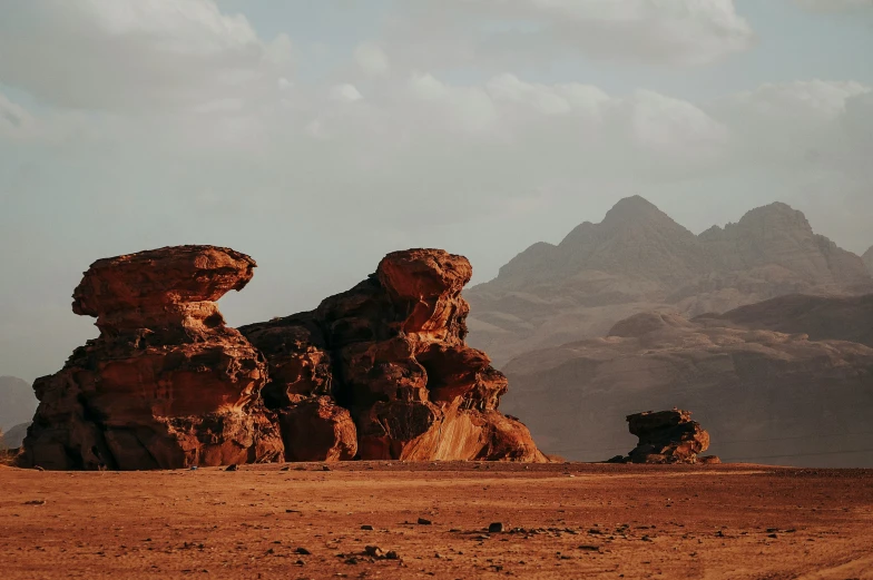 two large rocks sitting in the middle of a desert