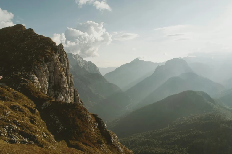 a mountain is surrounded by mountains with clouds above