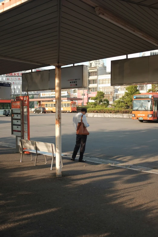 a person standing in the middle of a bus stop