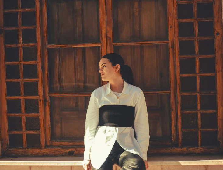 a woman standing next to a wooden window