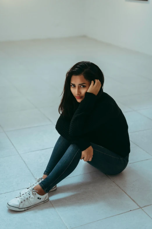 a woman is sitting down talking on a cell phone