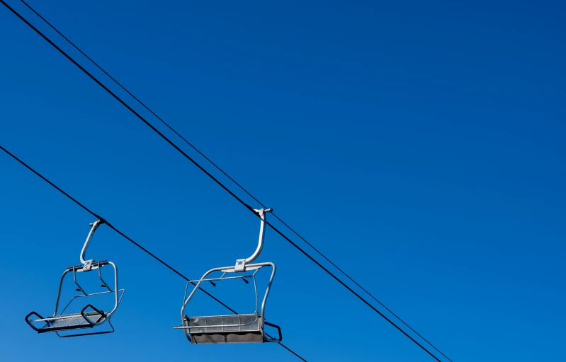 a pair of cable cars sit against the blue sky