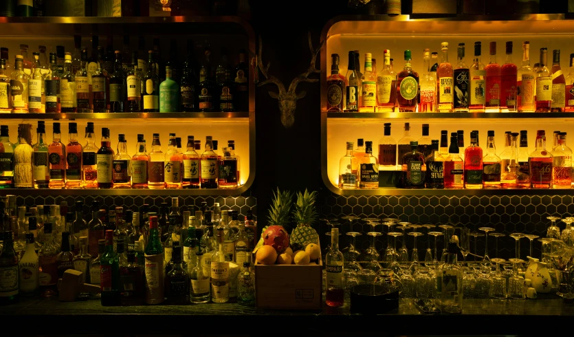 a group of different types of liquors and glasses on display