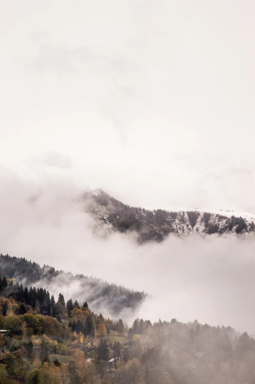 the clouds are beginning to float over the mountains