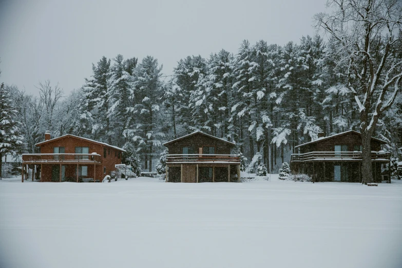 two small cabins sit in a snowy field