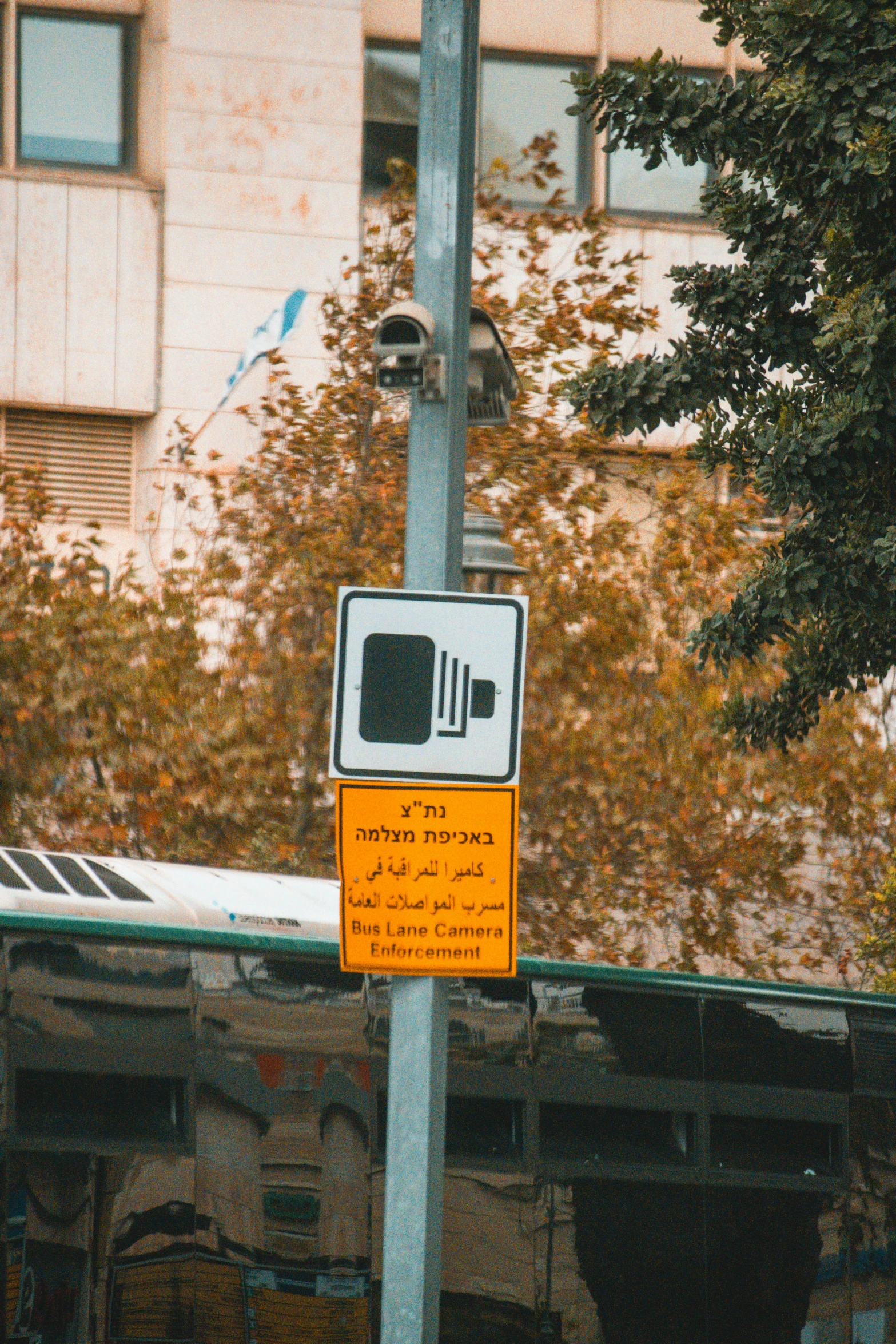 a parking sign and sign on a pole by some trees