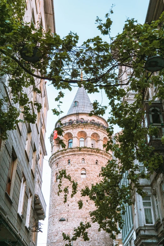 a view of a clock tower through some buildings