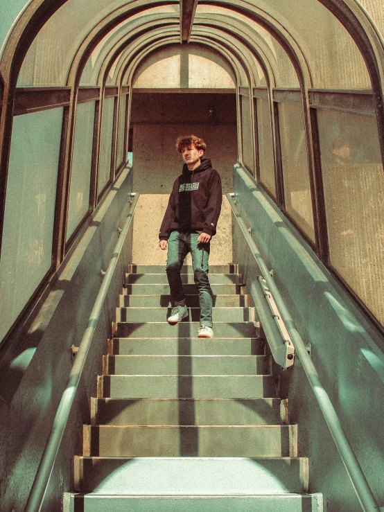 the young man is standing on a set of stairs