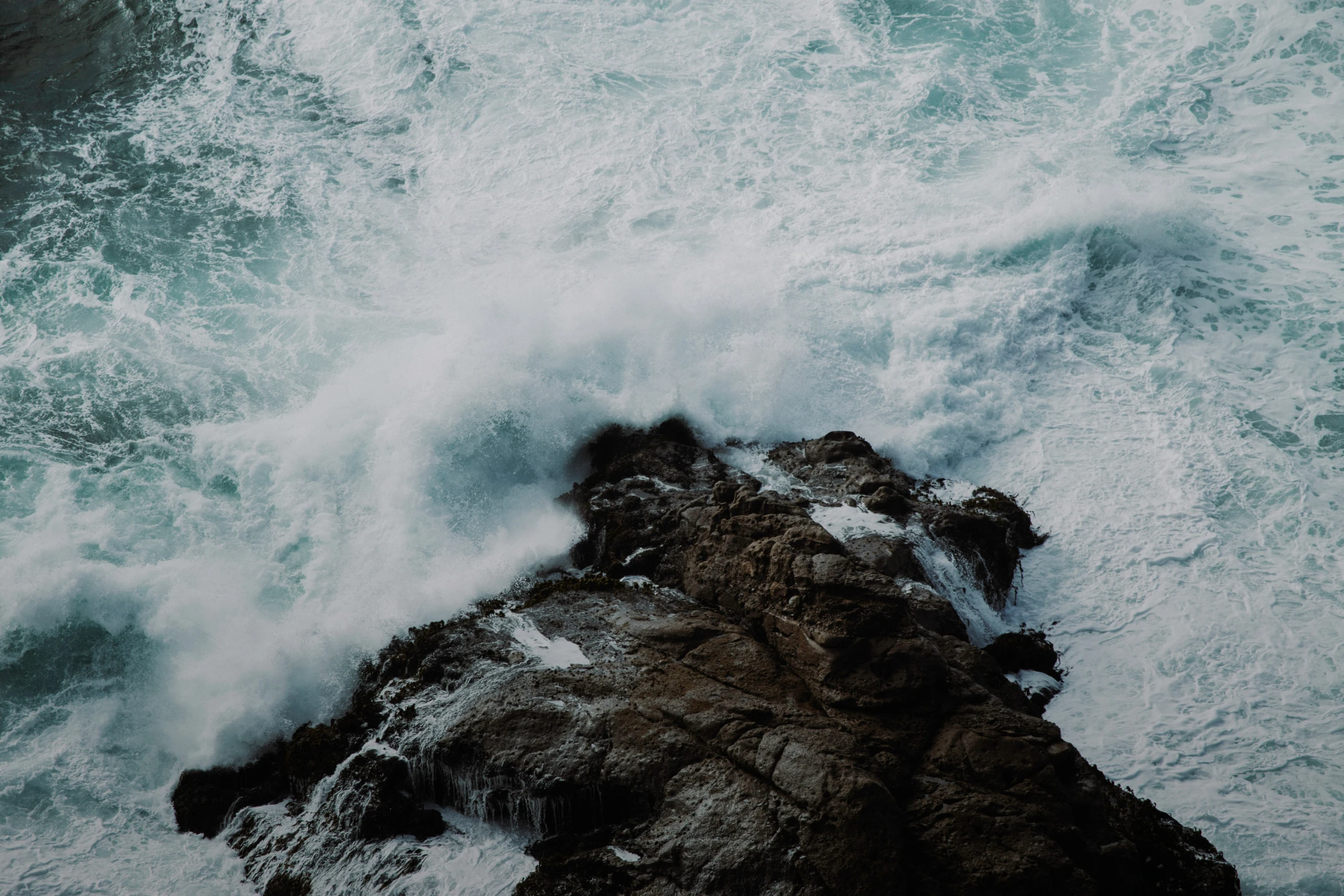 an image of a wave crashing over the rocks