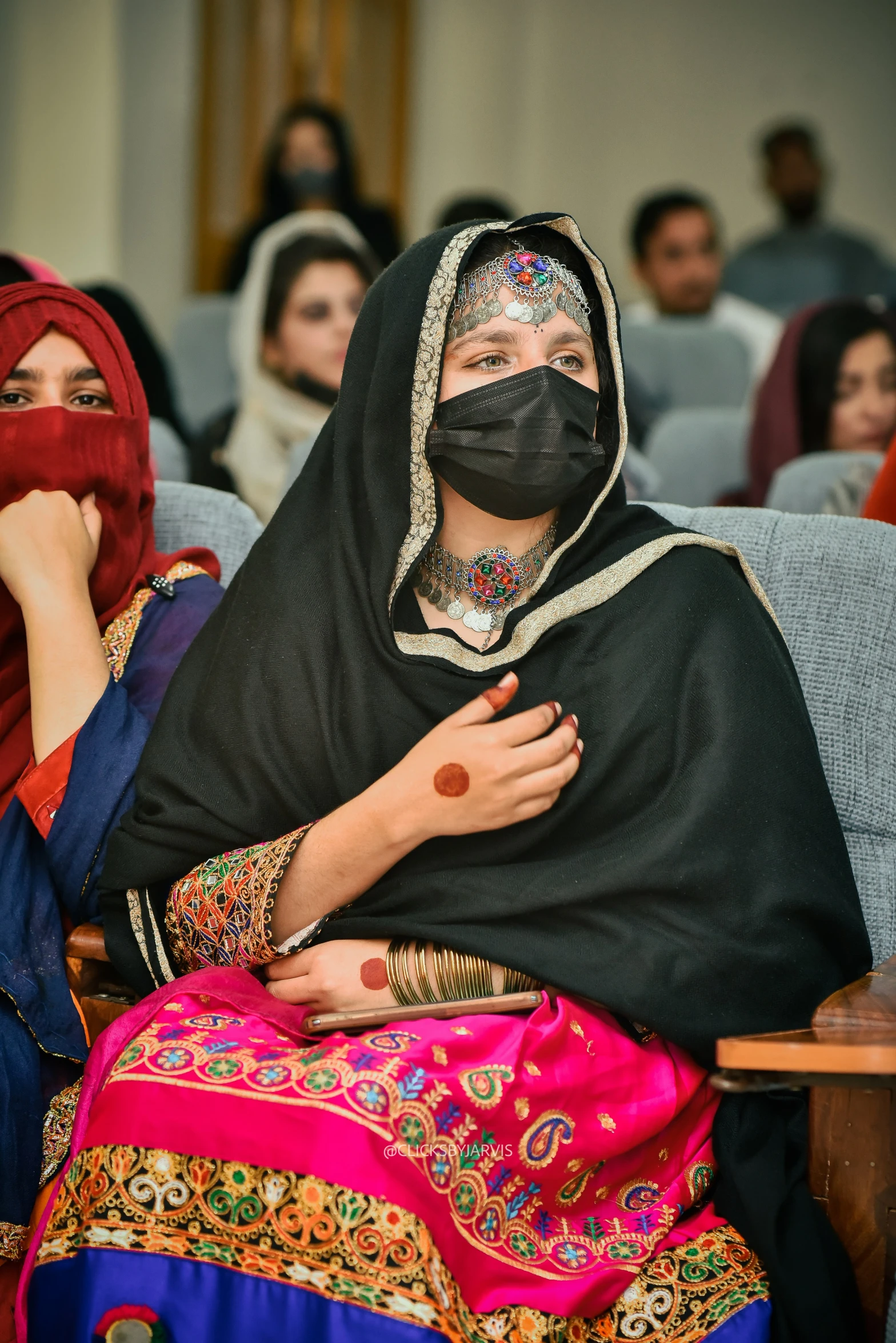 women in veils and head covering sit on chairs