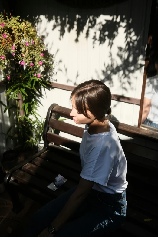 a  sitting on a bench in the sun